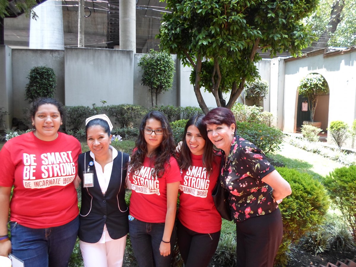 Three students, Graciela, and a nurse infront of a ministry